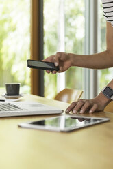 Woman at table with cell phone, laptop and digital tablet - SBOF000084