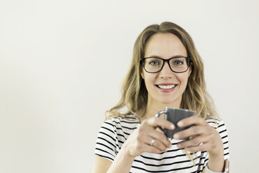 Portrait of smiling woman with cup of coffee - SBOF000086