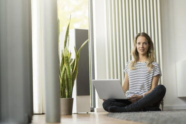 Woman at home sitting on floor with laptop - SBOF000088