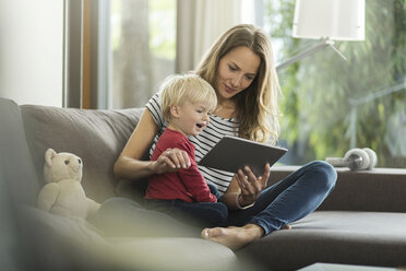 Mother and son on couch with digital tablet - SBOF000102