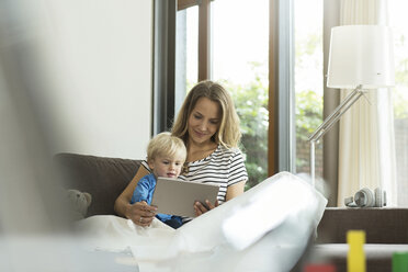 Mutter und Sohn auf der Couch mit digitalem Tablet - SBOF000103