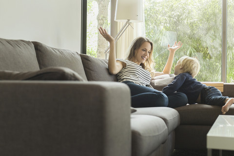 Mutter und Sohn spielen zu Hause auf der Couch, lizenzfreies Stockfoto