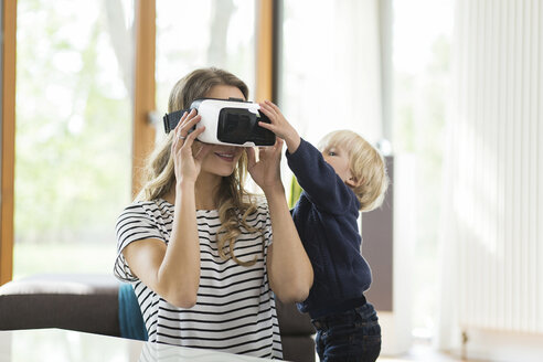 Mutter mit Sohn trägt Virtual-Reality-Brille - SBOF000119