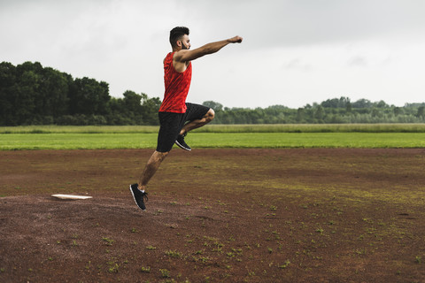 Athlet springt auf Sportplatz, lizenzfreies Stockfoto