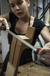 Luthier manufacturing a guitar in her workshop - ABZF000704