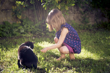 Kleines Mädchen mit Katze im Garten - LVF004965