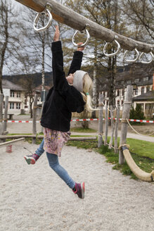 Mädchen benutzt Spielgeräte auf dem Spielplatz - TCF004981