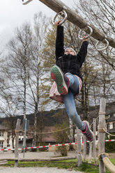 Mädchen benutzt Spielgeräte auf dem Spielplatz - TCF004982