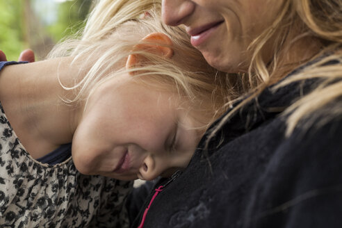 Smiling little girl with eyes closed near to her mother - TCF004987