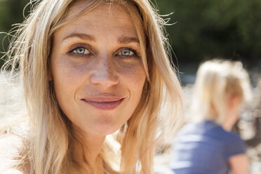 Porträt einer lächelnden blonden Frau mit Sommersprossen - TCF004990