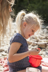 Porträt eines lächelnden kleinen Mädchens am Flussufer - TCF004991