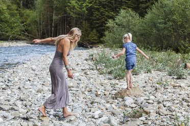 Mother and her little daughter walking at stony riverside - TCF004995