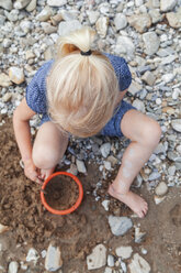 Blondes kleines Mädchen spielt mit Sand in der Natur - TCF005001