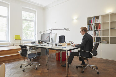 Businessman working with notebook in an office - RHF001616