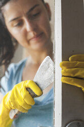 Junge Frau renoviert altes Fenster - BZF000302