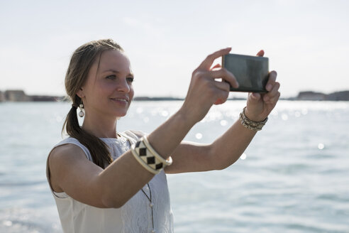 Italien, Venedig, Tourist macht ein Selfie mit Smartphone - MAUF000654