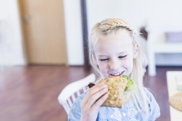 Smiling girl eating bread roll - MJF001851