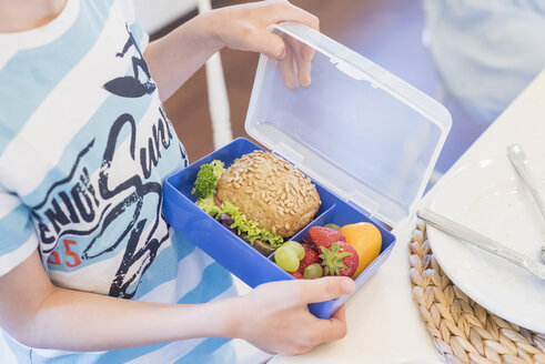 Boy packing lunch box with healthy food - MJF001854