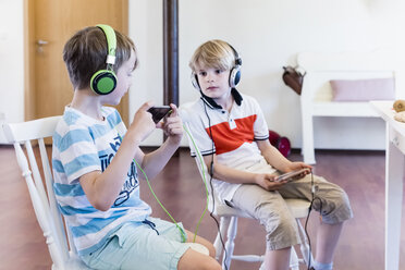 Zwei Jungen mit Handys und Kopfhörern - MJF001882