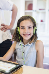 Porträt eines lächelnden Mädchens mit digitalem Tablet und Kopfhörern - MJF001888