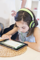 Mädchen mit Kopfhörern und digitalem Tablet - MJF001889