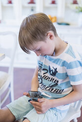 Boy sitting looking at cell phone - MJF001891