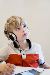 Boy wearing headphones looking up - MJF001898