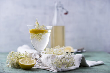 Ein Glas Wasser, aromatisiert mit Holunderblütensirup und Zitrone - MYF001531