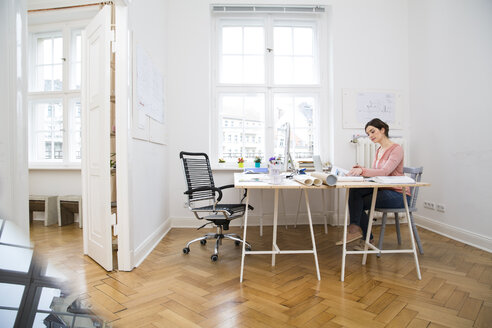 Frau arbeitet im Büro - FKF001849