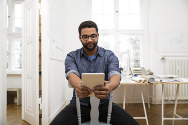 Junger Mann benutzt digitales Tablet im Büro - FKF001855