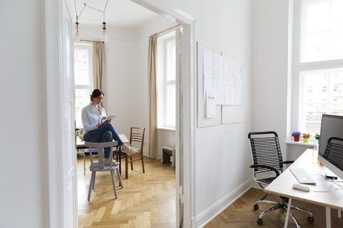 Young woman using digital tablet in office - FKF001877