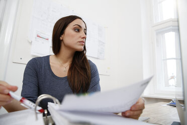 Woman working on files at office desk - FKF001892