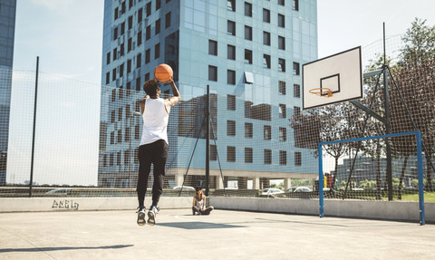 Junger Mann zielt auf Basketballkorb, lizenzfreies Stockfoto