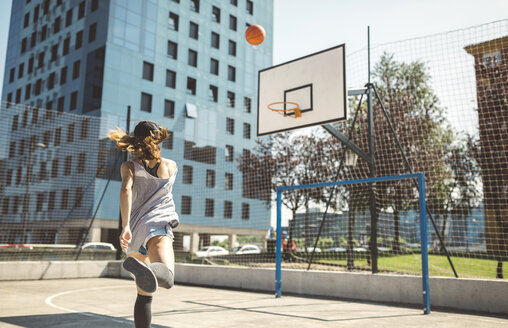 Junge Frau, die auf einen Basketballkorb zielt - DAPF000153