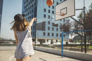 Junge Frau, die auf einen Basketballkorb zielt - DAPF000154