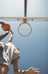 Junges Paar spielt Basketball auf dem Platz - DAPF000159