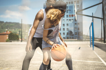 Young couple playing basketball on court - DAPF000179