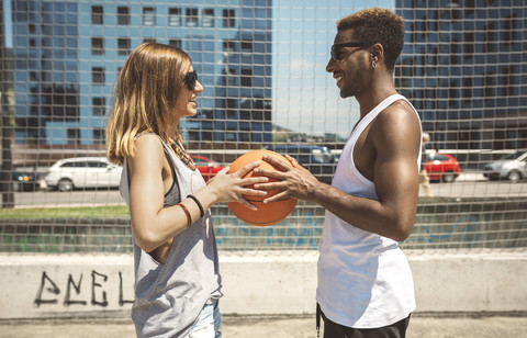Junges Paar hält Basketball, lizenzfreies Stockfoto