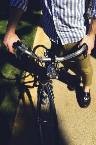Junger Mann mit Fahrrad, Teilansicht, lizenzfreies Stockfoto