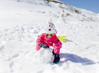 Mädchen baut einen Schneemann - MGOF001963