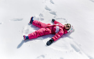 Little girl making a snow angel - MGOF001966