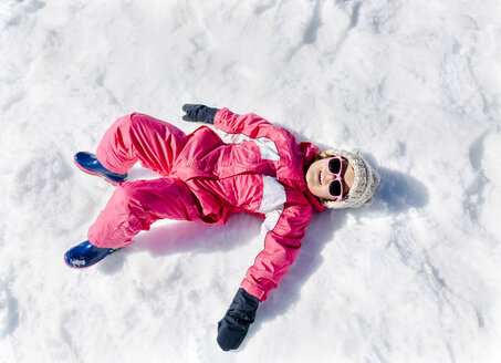 Kleines Mädchen spielt im Schnee, liegend - MGOF001973