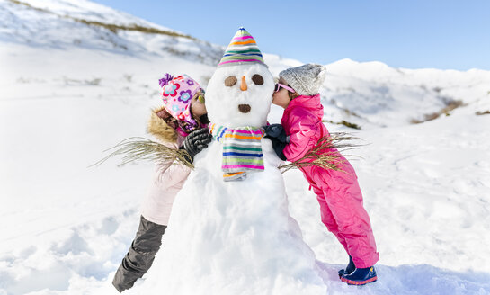 Spanien, Asturien, Kinder spielen mit Schneemännern, küssen - MGOF001982