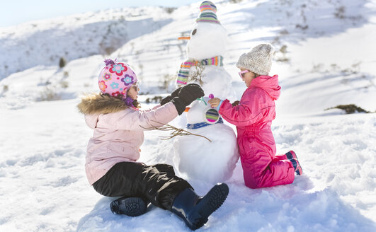 Spanien, Asturien, Kinder spielen mit Schneemännern in einem verschneiten Gebirge - MGOF001983