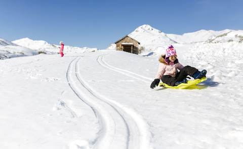 Spanien, Asturien, Mädchen mit Schlitten im Schnee, Schlittenfahren, lizenzfreies Stockfoto