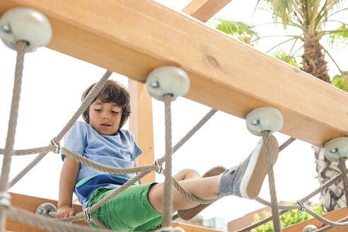 Kleiner Junge klettert auf Hängebrücke eines Spielplatzes - VABF000571