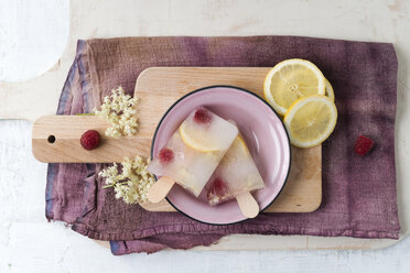 Homemade elderflower lemon raspberry ice lollies in bowl - MYF001567