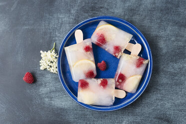 Homemade elderflower lemon raspberry ice lollies on plate - MYF001570