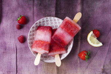 Homemade strawberry raspberry lemon ice lollies in bowl - MYF001574