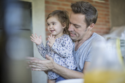 Vater und kleine Tochter klatschen in die Hände, lizenzfreies Stockfoto